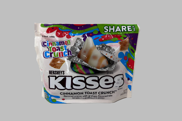 Hershey's Kisses Cinnamon Toast Crunch candy package on a white surface with a gray background